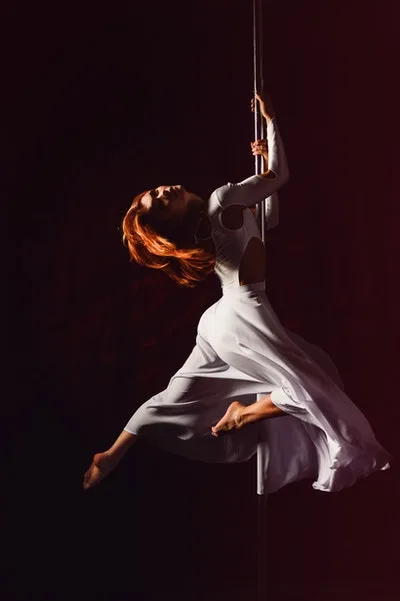Adults learning pole dance at a dance class in Newport